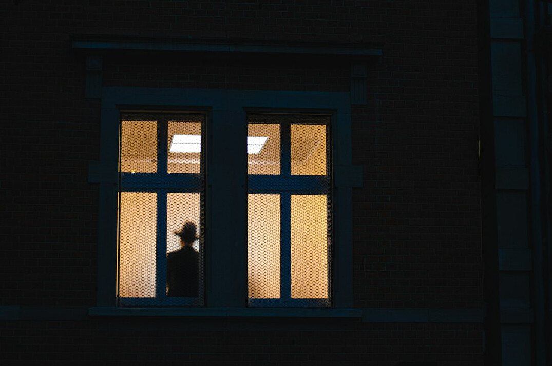 person looking out window at night