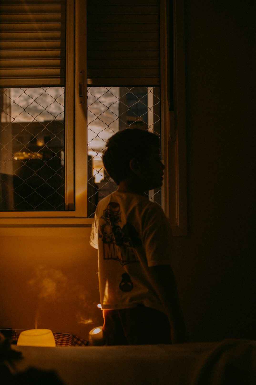 person looking out window at night